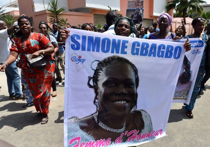 Devant la résidence de Simone Gbagbo à Abidjan, des supporters en liesse brandissent son portrait le 8 août en attendant son retour. (Photo AFP/Issoufou Sanogo)