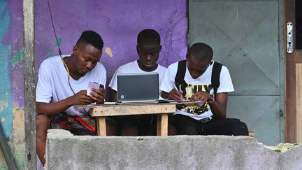 De jeunes Ivoiriens surfent sur internet dans le quartier populaire d'Abobo, à Abidjan (Côte d'Ivoire), le 14 février 2020. (ISSOUF SANOGO / AFP)