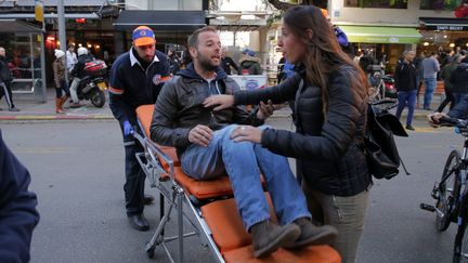 Un blessé est évacué après l'attaque d'un bar, le 1er janvier 2016, à Tel-Aviv (Israël). (DANIEL BAR ON / AFP)