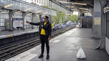 Un jeune homme avec un masque à la station de métro&nbsp;Barbès-Rochechouart, le 17 avril 2020, à Paris. (FRANCK RENOIR / HANS LUCAS / AFP)