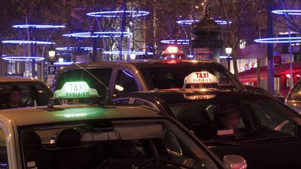 Des taxis parisiens sur les Champs-Elys&eacute;es, en d&eacute;cembre 2011. (JACQUES LOIC / PHOTONONSTOP / AFP)