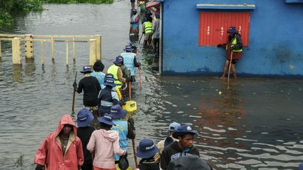 Des habitants marchent dans une rue inondée à&nbsp;Antananarivo (Madagascar), le 24 janvier 2022. (RIJASOLO / AFP)