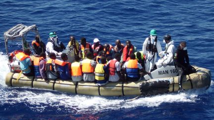 Une embarcation de migrants secourue par la marine italienne, au large de la Sicile, en septembre 2014. (AFP PHOTO / MARINA MILITARE ITALIANA)