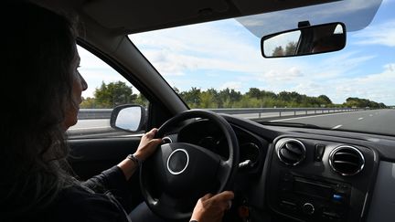 Une femme conduisant une voiture sur une autoroute.&nbsp; (RICHARD VILLALON / MAXPPP)