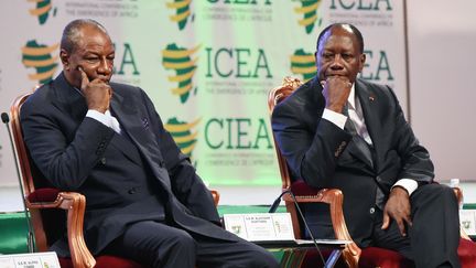 Le président guinéen, Alpha Condé (à gauche) et son homologue ivoirien Alassane Ouattara, lors d'une conférence internationale le 28 mars 2017 à Abidjan. Les deux chefs d'Etat sont au cœur d'une polémique sur le "syndrome du 3ème mandat" en Afrique. (SIA KAMBOU / AFP)