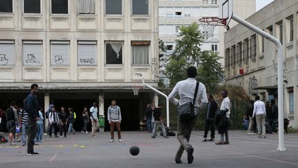 Des migrants dans la cour du coll&egrave;ge Guillaume-Bud&eacute;, dans le XIXe arrondissement de Paris, le 31 juillet 2015. (JACQUES DEMARTHON / AFP)