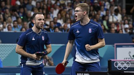 Simon Gauzy et Alexis Lebrun lors de leur match en double face à la Slovénie en huitièmes de finale du tournoi olympique de tennis de table aux JO de Paris le 5 août à l'Arena Paris Sud. (WANG ZHAO / AFP)