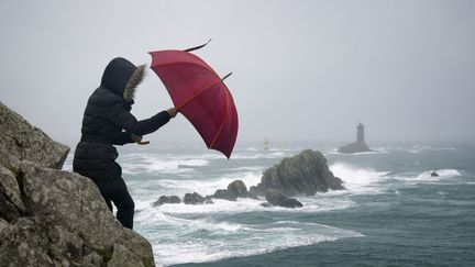 Une femme pendant une tempête dans le Finistère, à la Pointe du Raz, le 21 décembre 2015. (GARCIA JULIEN / HEMIS.FR / HEMIS.FR / AFP)