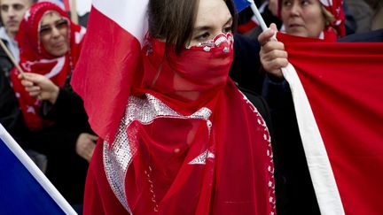 Entour&eacute;e d'un drapeau turc, une jeune femme manifeste contre la proposition de loi visant &agrave; p&eacute;naliser la n&eacute;gation des g&eacute;nocides, &agrave; proximit&eacute; du S&eacute;nat, &agrave; Paris, le 23 janvier 2012. (FRED DUFOUR / AFP)