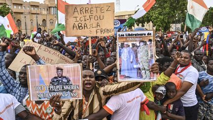 Un soutien du Conseil national pour la sauvegarde de la patrie (CNSP) brandit un panneau avec la figure du général putschiste Abdourahamane Tiani, le 20 août 2023 sur la Place de la Concertation à Niamey (Niger). (AFP)