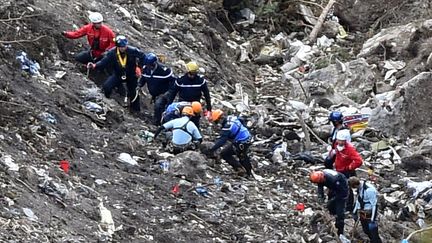 Des gendarmes poursuivent leurs investigations sur le lieu du crash de l'A320 de Germanwings, dans les Alpes-de-Haute-Provence, le 26 mars 2015. (ANNE-CHRISTINE POUJOULAT / AFP)