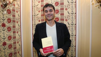 Laurent Binet pose avec son livre, apr&egrave;s la remise du prix Interalli&eacute;, &agrave; Paris, le 12 novembre 2015.&nbsp; (PATRICK KOVARIK / AFP)