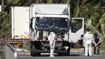 A Nice (Alpes-Maritimes), vendredi 15 juillet 2016, des enquêteurs inspectent la scène de l'attentat. (ERIC GAILLARD / REUTERS)