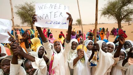 De jeunes Soudanaises accueillent une d&eacute;l&eacute;gation de la&nbsp;Mission conjointe des Nations unies et de l'Union africaine au Darfour &agrave; Forog (Darfour), le 30 mai 2012. (ALBERT GONZALEZ FARRAN / AFP)