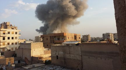 De la fum&eacute;e s'&eacute;chappe de Raqqa (Syrie), apr&egrave;s des frappes a&eacute;riennes de l'arm&eacute;e syrienne contre l'Etat islamique, le 25 novembre 2014.&nbsp; (ANADOLU AGENCY / AFP)