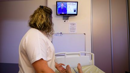 Une infirmière regarde l'allocution d'Emmanuel Macron, lundi 12 juillet 2021, depuis son hôpital.&nbsp; (PHOTOPQR/LA MONTAGNE/MAXPPP)