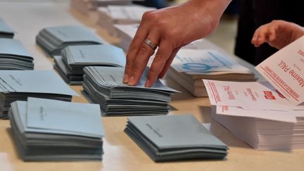 Un électeur prend des bulletins de vote lors du premier tour des législatives à Carhaix (Finistère), le 11 juin 2017. (MAXPPP)