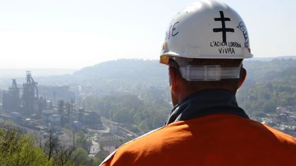 Un ouvrier de l'usine ArcelorMittal de Florange regarde le site &agrave; l'arr&ecirc;t depuis les hauteurs de Hayange, le 25 avril 2013. (JEAN-CHRISTOPHE VERHAEGEN / AFP)