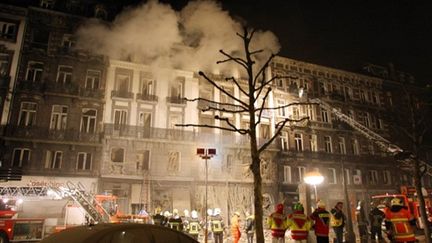 Les pompiers luttent contre le feu après l'explosion qui a secoué deux immeubles du centre de Liège (26/01/10) (AFP / Michel Krakowski)