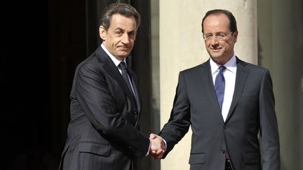 Nicolas Sarkozy accueille Fran&ccedil;ois Hollande &agrave; l'Elys&eacute;e lors de la passation de pouvoir, &agrave; Paris,&nbsp;15 mai 2012. (LIONEL BONAVENTURE / AFP)