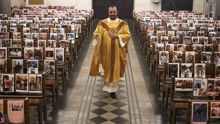 Le père Georges Nicoli, prêtre de Notre-Dame de Lourdes à Bastia, officie&nbsp;devant des photos de ses fidèles paroissiens, le 9 avril 2020 (photo d'illustration). (PASCAL POCHARD-CASABIANCA / AFP)