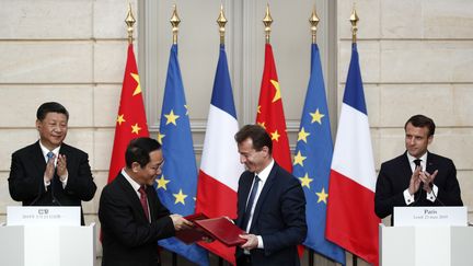 Le président de China Aviation Supplies Co., Jia Baojun, et le président d'Airbus Guillaume Faury&nbsp;signent un contrat devant Xi Jinping et Emmanuel Macron, le 25 mars 2019 à l'Elysée. (YOAN VALAT / POOL)