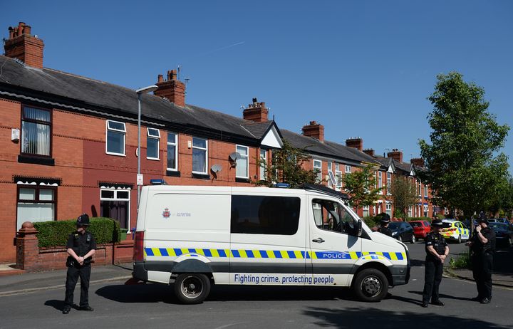 Des policiers britanniques bloquent l'accès à un site perquisitionné sur Dorset Avenue, dans le quartier de Moss Side à Manchester&nbsp;(Royaume-Uni), le 26 mai 2017. (OLI SCARFF / AFP)