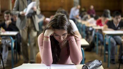 Une lyc&eacute;enne planche sur l'&eacute;preuve de philosophie du baccalaur&eacute;at g&eacute;n&eacute;ral, &agrave; Paris, le 16 juin 2014. (FRED DUFOUR / AFP)