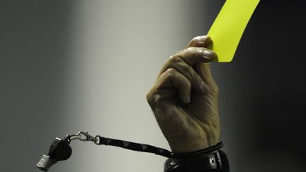 Un carton jaune dans la main d'un arbitre. (JUAN MABROMATA / AFP)