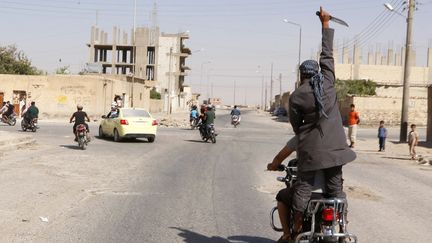 Des hommes paradent pour c&eacute;l&eacute;brer la prise de la ville de&nbsp;Tabqa,&nbsp;situ&eacute;e pr&egrave;s de Raqqa (Syrie), par l'organisation Etat islamique, le 24 ao&ucirc;t 2014. (REUTERS)