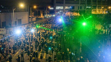 Pour&nbsp;empêcher&nbsp;les passants et les policiers de filmer leurs visages, les manifestants hongkongais se sont armés de lasers. (PHILIP FONG / AFP)