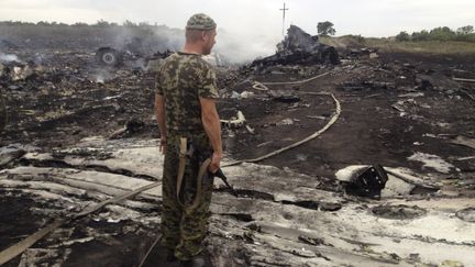Un s&eacute;paratiste pro-russe sur le site du crash du Boeing 777 de Malaysia Airlines, dans la r&eacute;gion de Donetsk, dans l'est de l'UKraine, jeudi 17 juillet 2014. (MAXIM ZMEYEV / REUTERS)