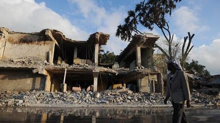 Un civil somalien passe devant un hôtel détruit à la suite d'une attaque des shebabs à Mogadiscio le 26 février 2016. (AFP - MOHAMED ABDIWAHAB)