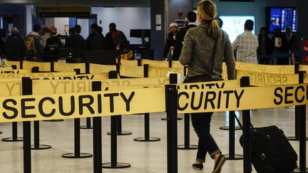 Une passag&egrave;re se dirige vers un contr&ocirc;le de s&eacute;curit&eacute;, le 11 octobre 2014, &agrave; l'a&eacute;roport international JFK de New York (Etats-Unis). (EDUARDO MUNOZ / REUTERS)