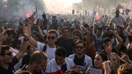 Des milliers de Français célèbrent l'arrivée des joueurs de l'équipe de France sur les Champs-Élysées à Paris, le 16 juillet.&nbsp; (LUCAS BARIOULET / AFP)