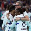 Olivier Krumbholz enlacé par Estelle Nze Minko et Coralie Lassource après la victoire des Bleues en demi-finales du tournoi olympique contre la Suède, le 8 août 2024 à Villeneuve-d'Ascq (Nord). (THOMAS COEX / AFP)