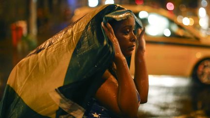 Une Br&eacute;silienne encaisse le coup apr&egrave;s la d&eacute;faite de l'&eacute;quipe du Br&eacute;sil face &agrave; l'Allemagne, dans une rue de&nbsp;Rio de Janeiro (Br&eacute;sil), le 8 juillet 2014. (JORGE SILVA / REUTERS)