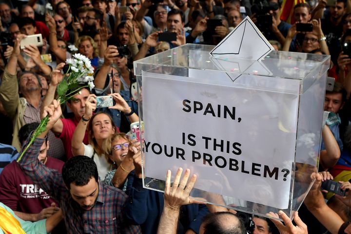 Des manifestants brandissent une urne symbolique, lors d'une manifestation&nbsp;en faveur de l'indépendance devant le siège du gouvernement régional de Catalogne,&nbsp;à Barcelone (Espagne), le 20 septembre 2017. (LLUIS GENE / AFP)