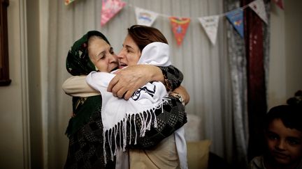 L'avocate des droits de l'homme Nasrin Sotoudeh (&agrave; droite), prend sa belle-m&egrave;re dans ses bras apr&egrave;s sa lib&eacute;ration, le 18 septembre 2013 &agrave; T&eacute;h&eacute;ran (Iran). (BEHROUZ MEHRI / AFP)