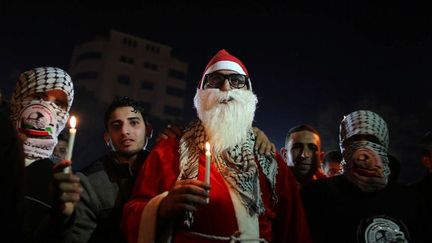 Des hommes masqués en compagnie d'un homme déguisé en père Noël dans la ville de Gaza, le 25 décembre 2015,  lors d'un rassemblement en hommage à des Palestiniens tués par des  tirs israéliens. (AFP/ Momen Faiz/NurPhoto)