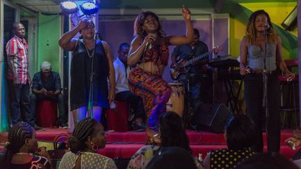 Accompagnée d'une chorale et d'un groupe, Olivia Beyene interprète un morceau de bikutsi et danse sur la scène du cabaret Québec à Yaoundé, le 2 octobre 2019. (STR / AFP)