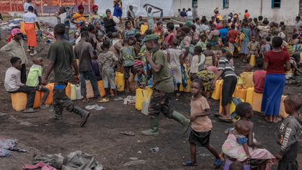 Des soldats de l'armée congolaise parmi des civils déplacés, au camp de Bulengo à quelques kilomètres de Goma, à l'est de la République démocratique du Congo, le 16 février 2024. (GUERCHOM NDEBO / AFP)