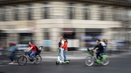 Des utilisateurs de trottinettes électriques au milieu de la circulation parisienne, le 13 septembre 2019. (MARTIN BUREAU / AFP)