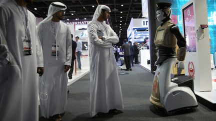 Des visiteurs regardent le premier robot policier présenté lors de&nbsp;la Gulf Information Security Expo and Conference (Gisec), le 22 mai 2017 à Dubaï. (ASHRAF MOHAMMAD MOHAMMAD ALAMRA / REUTERS)