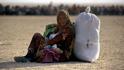 Une Irakienne fuit avec son enfant la ville de Mossoul, contr&ocirc;l&eacute;e par l'Etat islamique, en Irak, le 22 octobre 2016. (DELIL SOULEIMAN / AFP)