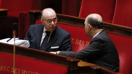 Le ministre d&eacute;l&eacute;gu&eacute; au Budget, Bernard Cazeneuve (de face), discute avec le ministre de l'Economie, Pierre Moscovici, dans l'h&eacute;micycle de l'Assembl&eacute;e nationale &agrave; Paris, le 5 f&eacute;vrier 2014. (PATRICK KOVARIK / AFP)