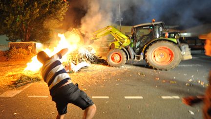 Un agriculteur jette des œufs sur l'usine Sodiaal, le 12 juillet 2016 au Mans (Sarthe). (JEAN-FRANCOIS MONIER / AFP)