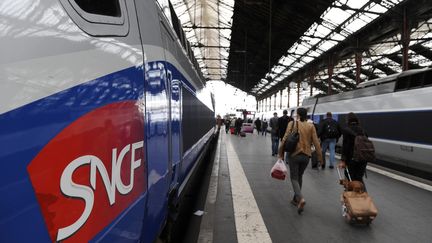 Des usagers de la SNCF marchent sur le quai &agrave; c&ocirc;t&eacute; de TGV avant le d&eacute;part de leur train le 6 octobre 2011 en gare de Lyon &agrave; Paris. (MIGUEL MEDINA / AFP)