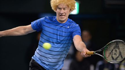 L'ancien joueur de tennis professionnel John McEnroe porte une perruque lors d'une match de tennis caritatif &agrave; Tokyo (Japon), le 17 novembre 2013. (TORU YAMANAKA / AFP)