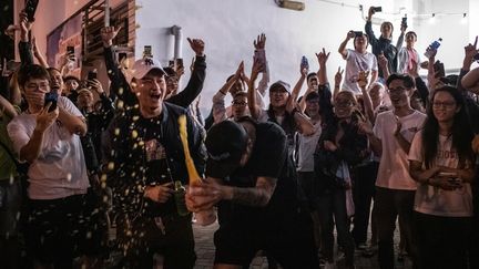 Des militants pro-démocratie célèbrent la victoire d'un candidat pro-démocratie, dans le district de Tuen Mun, à Hong Kong, le 25 novembre 2019. (PHILIP FONG / AFP)